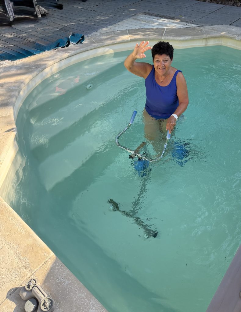 Évelyne dans sa piscine avec le bras libéré du plâtre